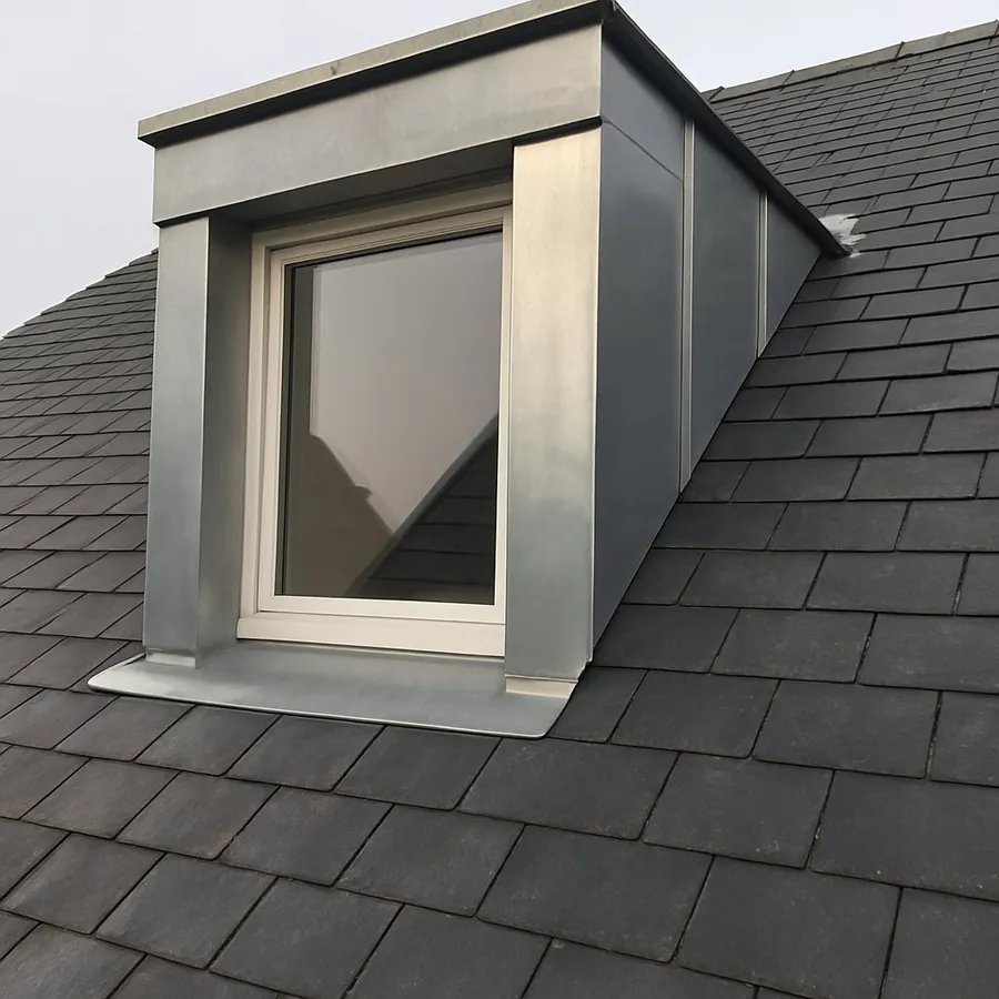 Lucarne entièrement habillée de zinc sur une toiture en ardoise